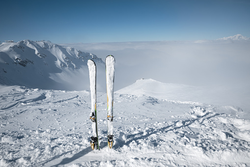 Pair of skis on top of ski slope with view on the mountains. Val Thorens, France.