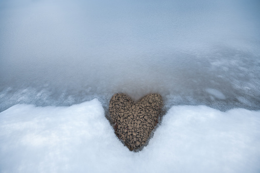 Heart shape visible on a shore of a frozen lake.