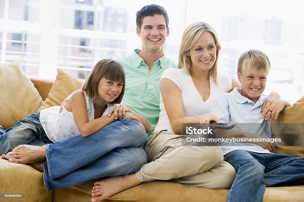 Famille assis dans la salle de séjour avec télécommande - Photo de Adulte libre de droits