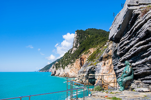 Coastline of the Liguria east coast as seen from Porto Venere. The sculpture leaning against the rock is titled 'Mater Naturae' an is a work by Lello Scorzelli, dated 1989.