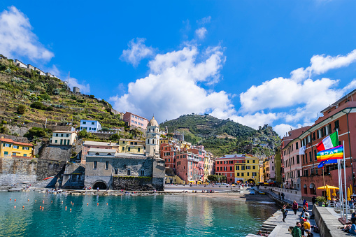 Tourists visiting the seaside village of Vernazza in the Cinque Terre, characterized by the pastel colored buildings facing the sea