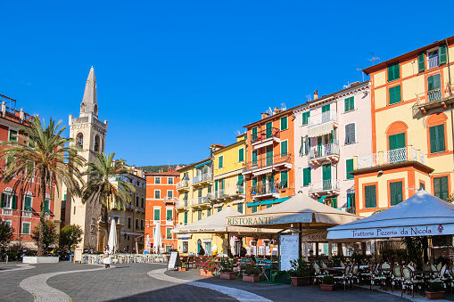 Piazza Garibaldi in Lerici bordered by pastel colored buildings and by the Oratory of San Rocco with its imposing bell tower