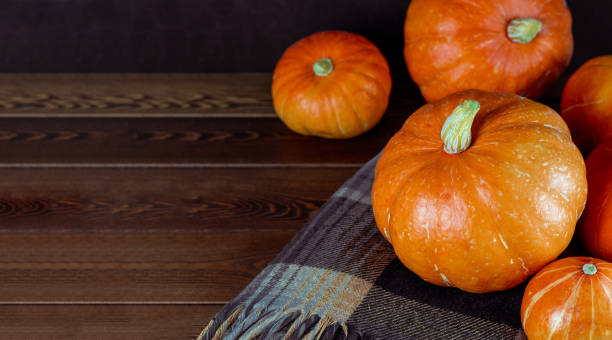 istock Pumpkins on a dark wooden background and a checkered plaid with space for text. autumn background 1419503849