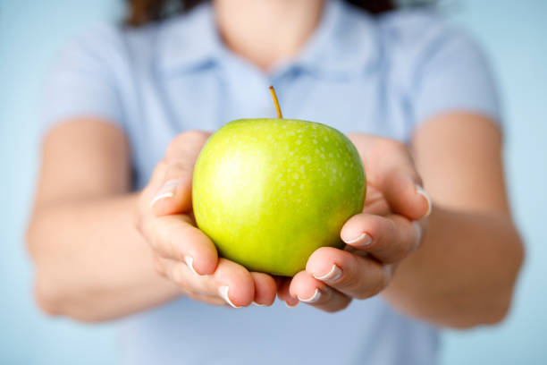 Woman holding green apple. Healthy diet foods