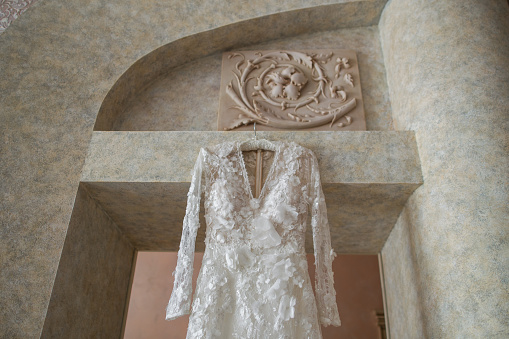 Wedding dress hanging on the door arch.