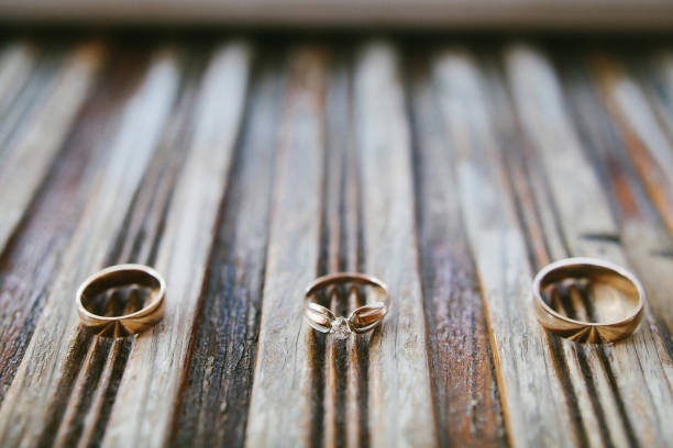 istock Three wedding rings on a wooden striped board 1419509911