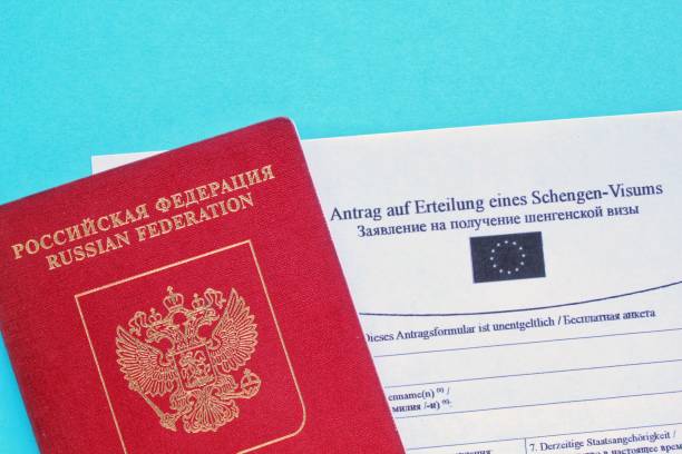 istock Passport and Schengen visa application form in Russian and Deutsch language on blue background 1419510110