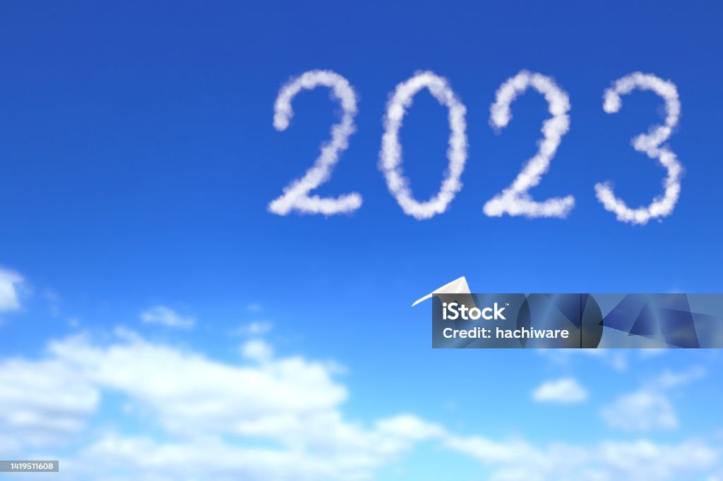 A paper airplane flies toward the 2023. The paper plane is heading for 2023 in the clear blue sky. 2023 Stock Photo