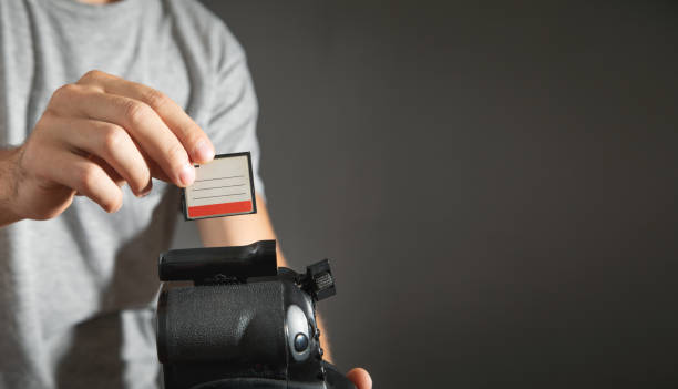 istock Photographer holding memory card insert DSLR camera. 1419515452