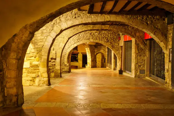 Stone arches in the basements of the medieval buildings of the old city of Besalu, Girona, Spain