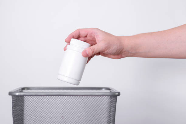 istock The hand tosses the white plastic can into the trash. 1419521863