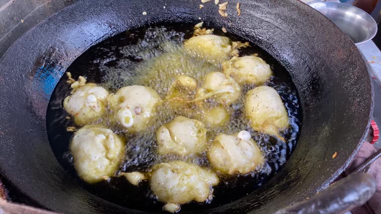 Nepalese traditional dumpling momos fried in hot oil in local market in India