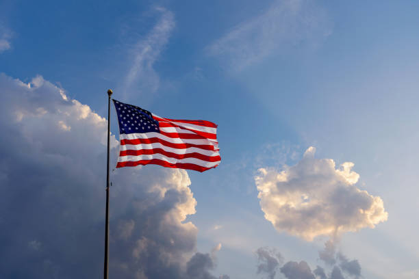 istock USA Flag flowing in the wind with dramatic sky in the background 1419525423