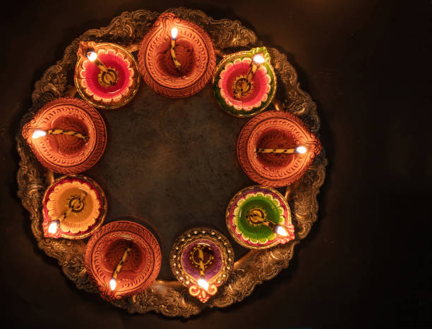 Diwali, Deepavali. Hindu Festival of lights celebration, India. Diya oil lamp Deepavali Diwali, Hindu Festival of lights celebration. Diya oil lamp lit on traditional Puja thali, top view. diwali photos stock pictures, royalty-free photos & images
