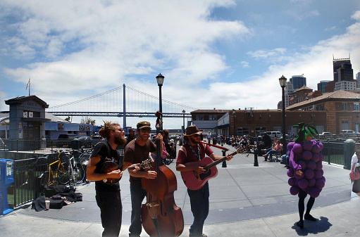 San Francisco - June 13, 2009: Jugtown Pirates play music at the Ferry Building Farmers Market as lady in grape costume dances.