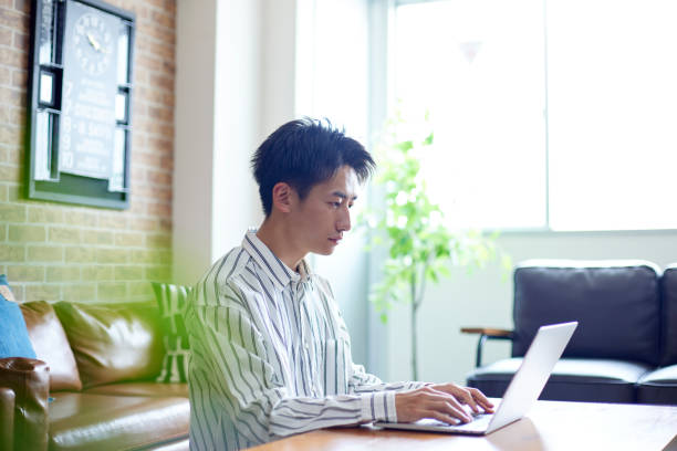 japonais se relaxant dans sa chambre - internet student business men photos et images de collection