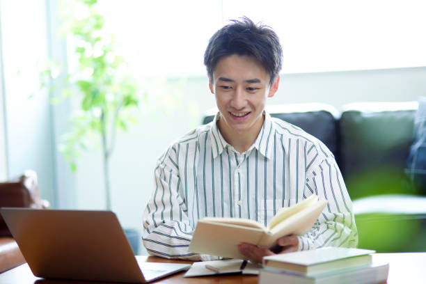 部屋でくつろぐ日本人男性 - learning male studying smiling ストックフォトと画像