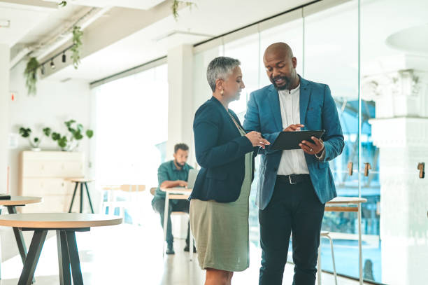 istock Business people talking digital tablet at work, planning website and looking for creative ideas on internet together in modern office. Employees and team discussing plan on technology in meeting 1419538145