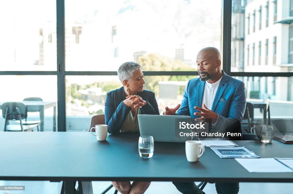 Business, presentation and man on a laptop in a corporate conference or office collaboration with a woman at work. Businessman, manager or coach for marketing, strategy and sales working with CEO. Business Person Stock Photo