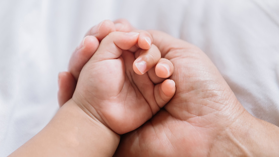Close up baby hand on mother's hands. family