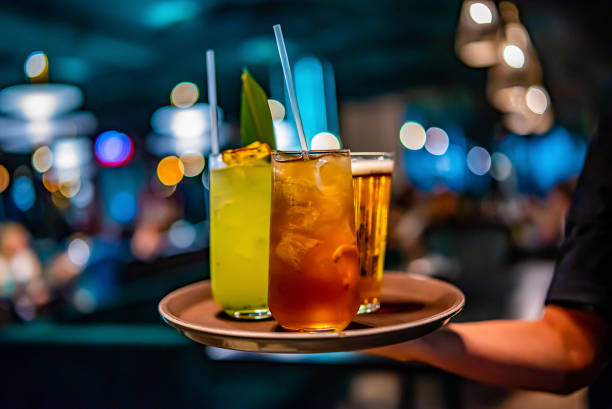 glasses alcohol cocktail set and beer on a waiter tray in bar - kokteyl stok fotoğraflar ve resimler