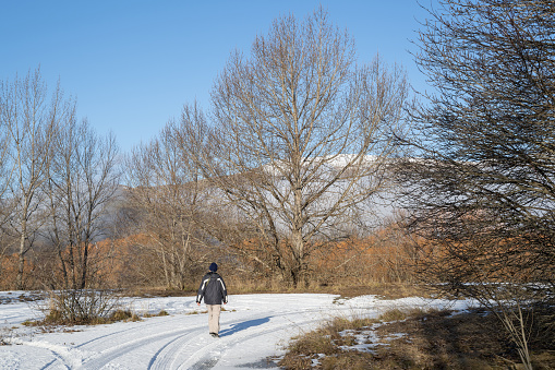 Man walking on the snow-covered ground, Twizel, South Island.