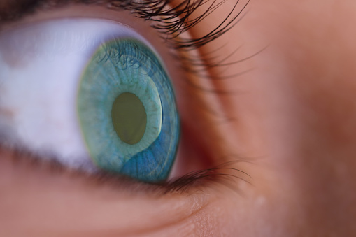 Macro shot of a human female eye, iris, cropped on black background, usable as creative background