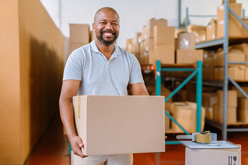 Shipping, logistics and supply chain with a man working in a warehouse, factory or plant with a box or package for delivery. Import, export and shipment via courier, freight or cargo packaging