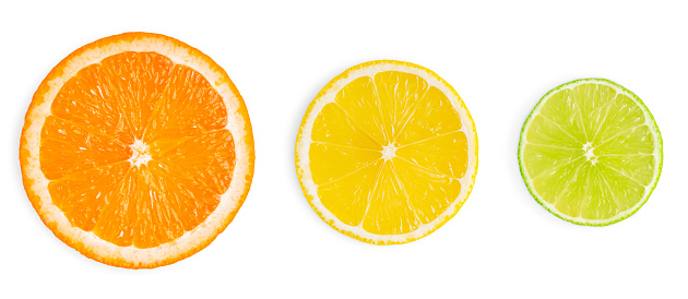 Three cross section or slices of juicy ripe citrus fruits such as orange, lemon and lime cut out on white backdrop used as ingredient in culinary or preparation of cocktails full of vitamin C