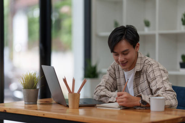 istock Graphic designer drawing in notebook and using laptop at home. Creative concept 1419559884