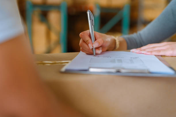 logística, planificación y liderazgo del gerente de almacén, escribiendo o firmando a mano el stock de inventario. empleado de fábrica, gerencia o trabajador con portapapeles que trabaja en el servicio de entrega o env�ío - document shipping freight transportation form fotografías e imágenes de stock