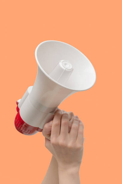 istock Megaphone in woman hands on an orange background. 1419563687