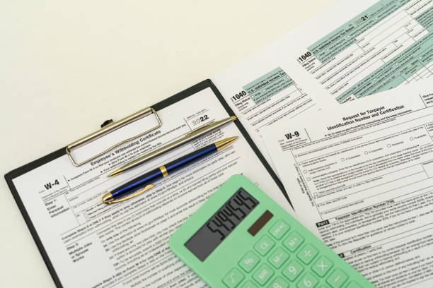 top view of tax forms on tablet on office desk with calculator and pen. stock photo