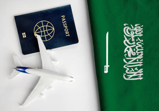 Flag of Saudi Arabia with passport and toy airplane. stock photo