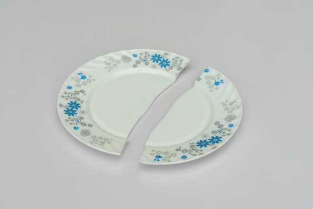 istock Broken white plate in half on isolated white background or concept of breaking up relations or divorce. 1419567825