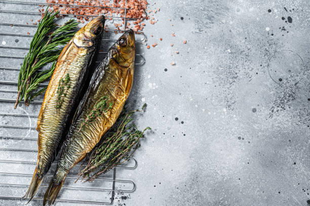 Smoked kippered whole herrings on smoker grill. Gray background. Top view. Copy space Smoked kippered whole herrings on smoker grill. Gray background. Top view. Copy space. kipper stock pictures, royalty-free photos & images