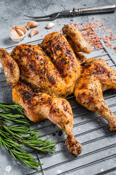 istock Traditional spatchcocked barbecue chicken on grill. Gray background. Top view 1419570382