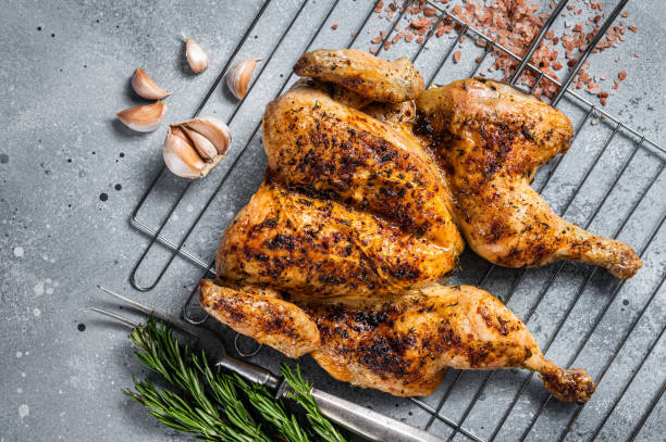 istock Traditional spatchcocked barbecue chicken on grill. Gray background. Top view 1419570398