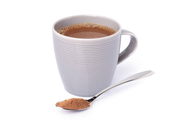 ホットチョコレート飲料のグラスマグカップとココアパウダーをステンレス製の小さじ1杯で白く隔離 - hot chocolate hot drink high section color image ストックフォトと画像