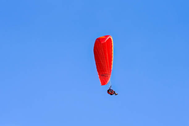 istock Paragliding in flight. Red and orange paraglider. 1419575845