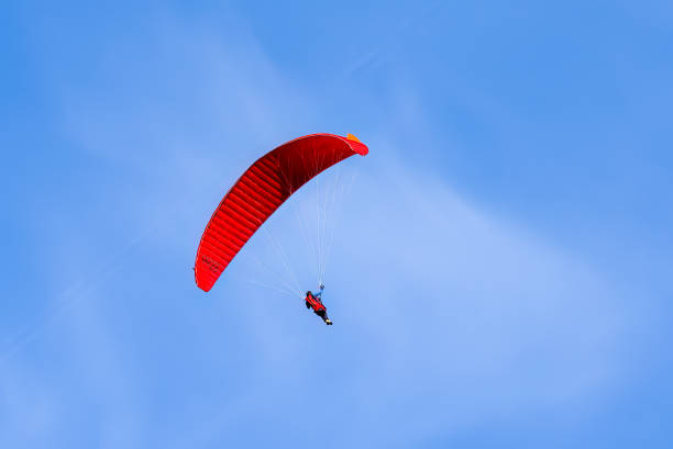 Paragliding in flight. Red and orange paraglider.