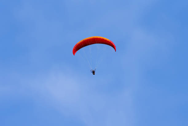 istock Paragliding in flight. Red and orange paraglider. 1419575914