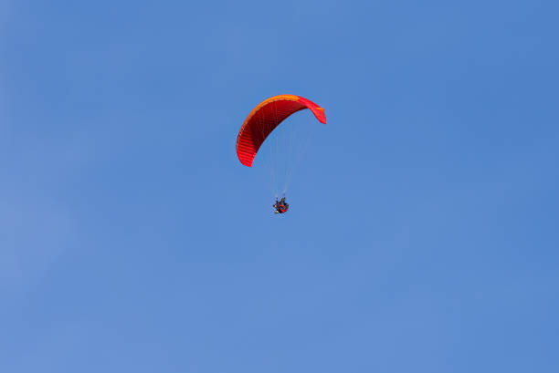 istock Paragliding in flight. Red and orange paraglider. 1419575930