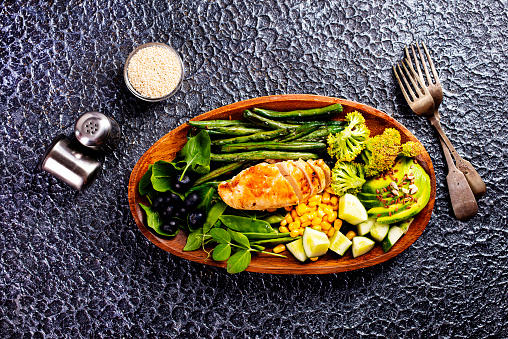 Big summer dinner with grilled chicken, green beans , corn and other vegetables