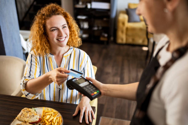 istock Smiling young making payment with credit card in restaurant 1419577325