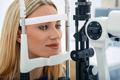 Beautiful blonde woman check-up her eyesight in ophthalmological clinic. Patient in ophthalmology clinic
