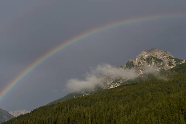 istock Rainbow in the dolomites sky, Campolongo di Cadore Val Comelico, Italy 1419579285