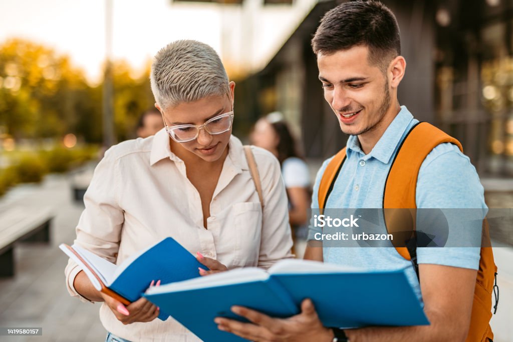 Introduction Two Students Two Students Discussing Their Class Notes On The University Campus ...