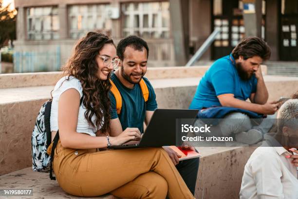 Two Students Discussing Their Class Notes On The University Campus Stock Photo - Download Image Now