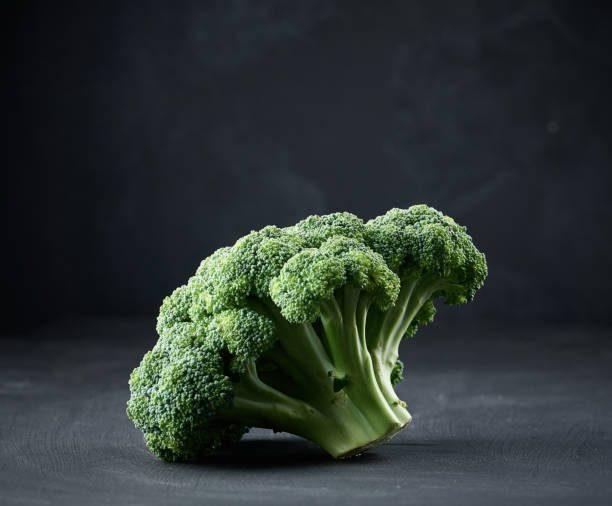 istock Fresh green head of broccoli on black background 1419582110